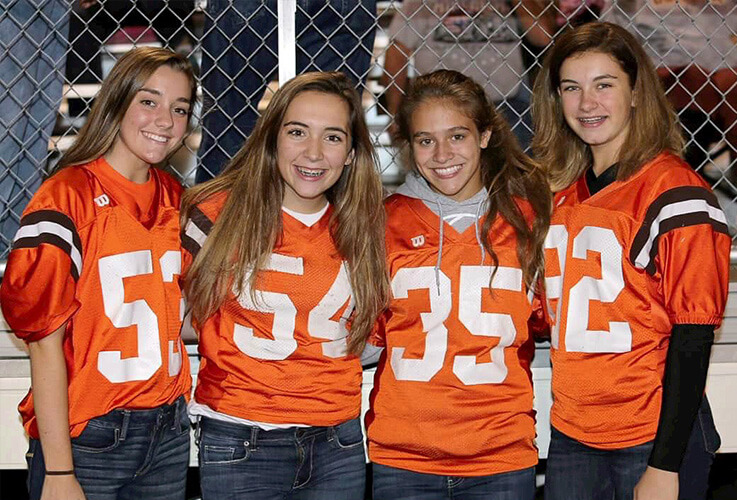 Four girls wearing football jerseys