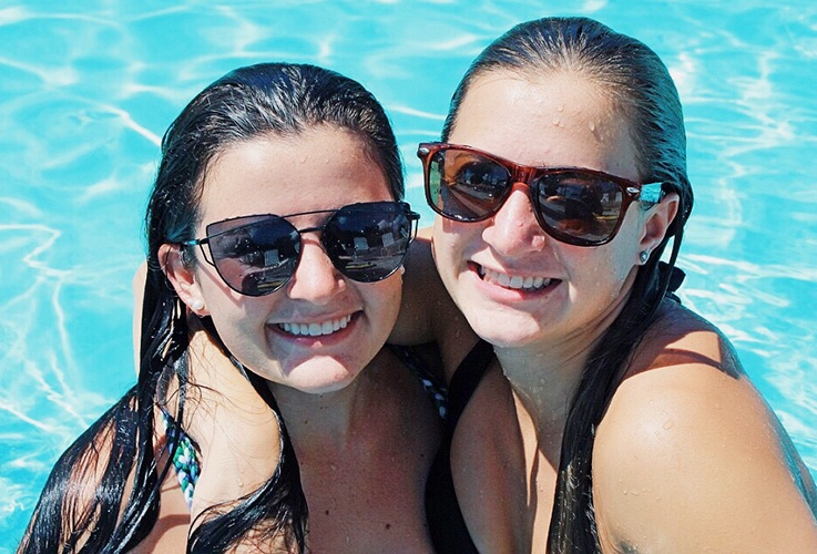 Two women with perfect teeth at pool