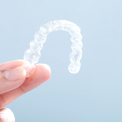 Patient holding up Invisalign in Heath