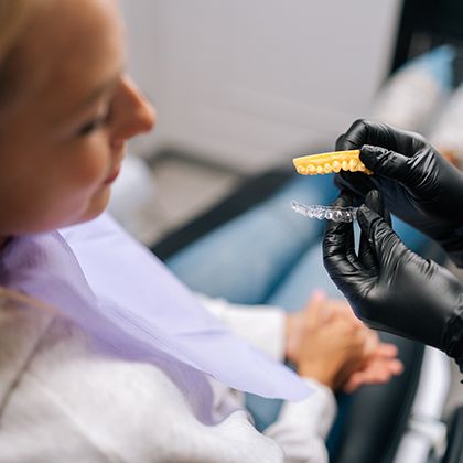 Patient looking at model of teeth with clear aligner
