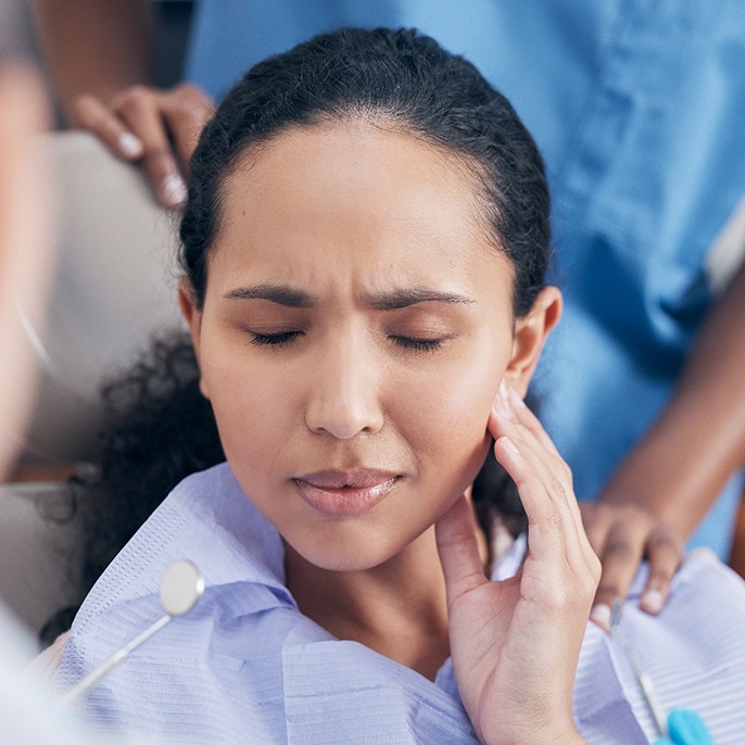 a person holding her mouth in pain