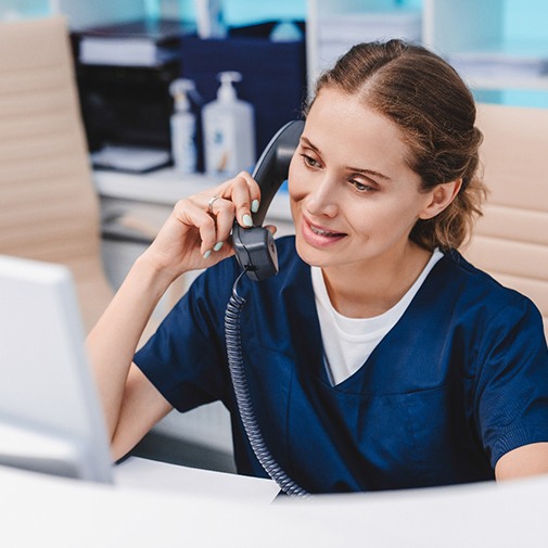 front desk staff at a dental office on the phone with a patient
