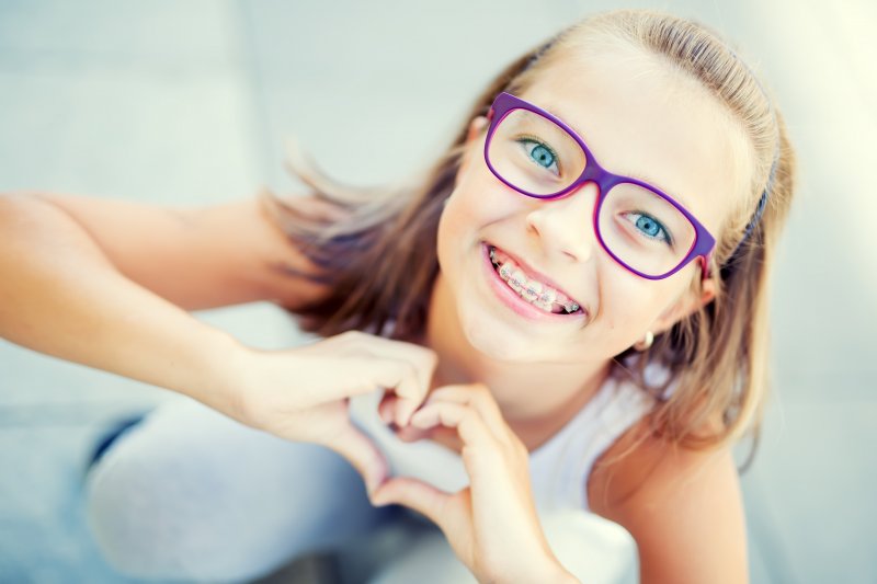Young girl smiling wearing braces.