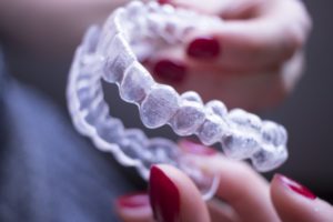 person holding Invisalign aligners