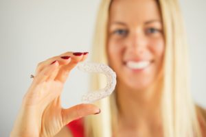 young woman smiling wearing Invisalign aligner