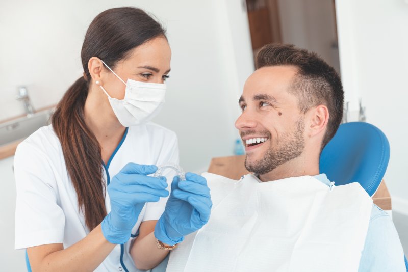 Smiling orthodontist and patient discussing Invisalign.