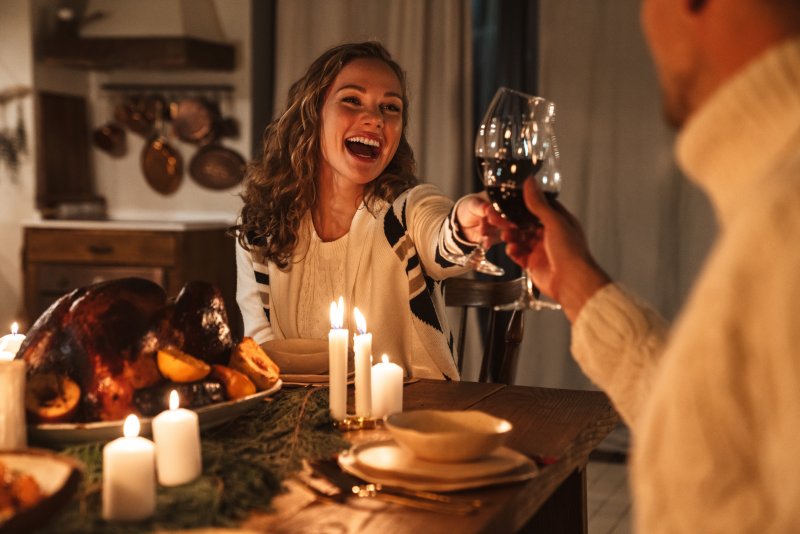 Woman smiling with friend at holiday dinner