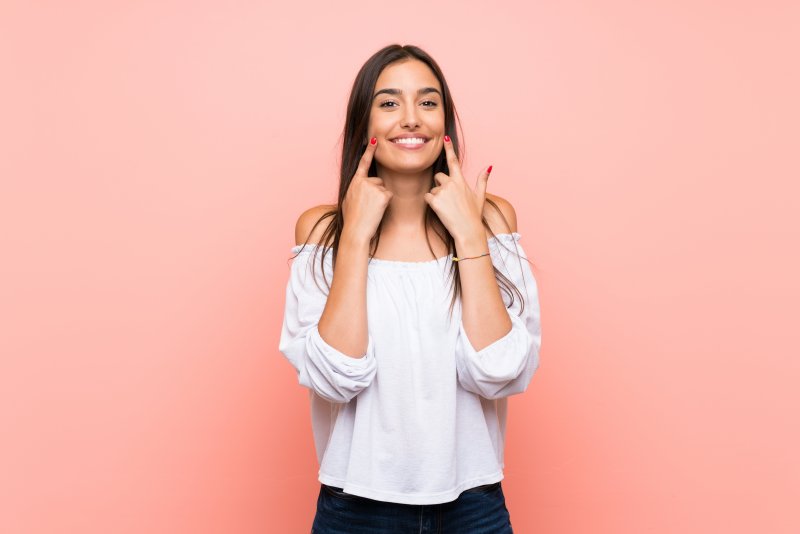 Woman pointing to her straight teeth