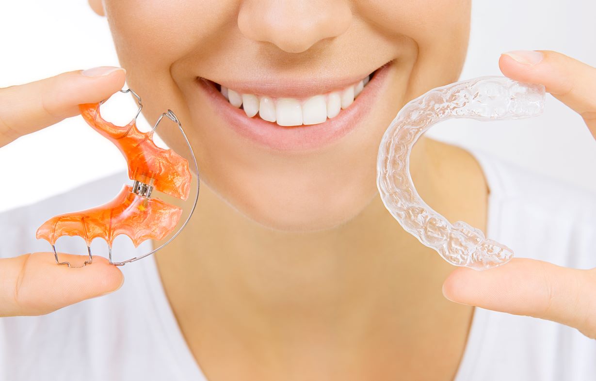 A woman holding two retainers.