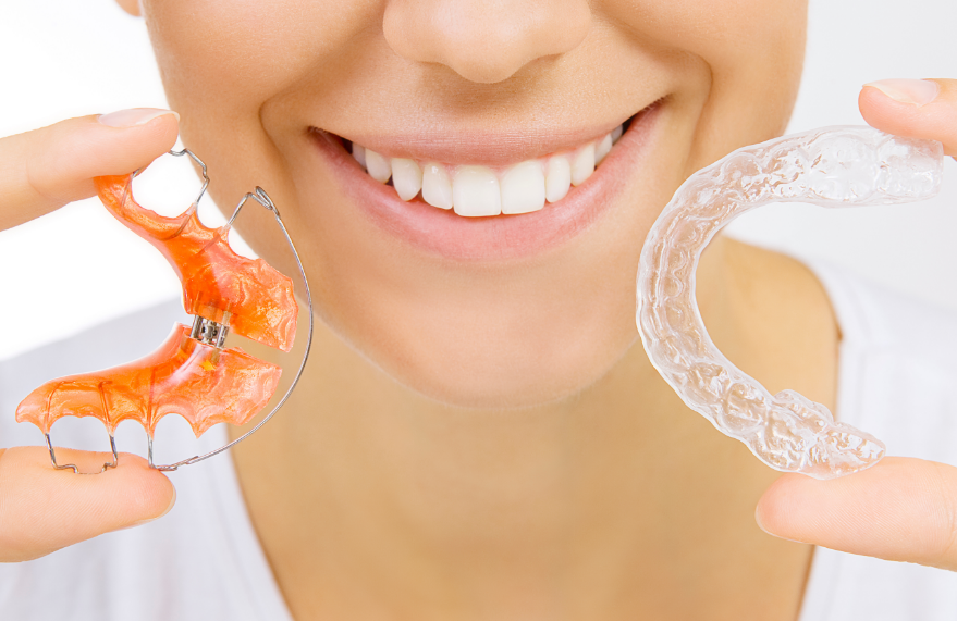 Woman holding dental retainers.